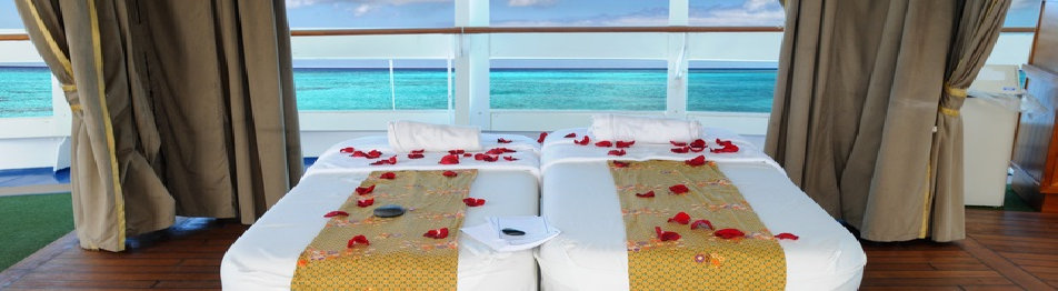 Two spa treatment beds overlooking turquoise ocean water